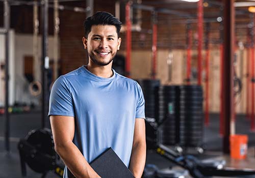 Man standing in the gym smiling